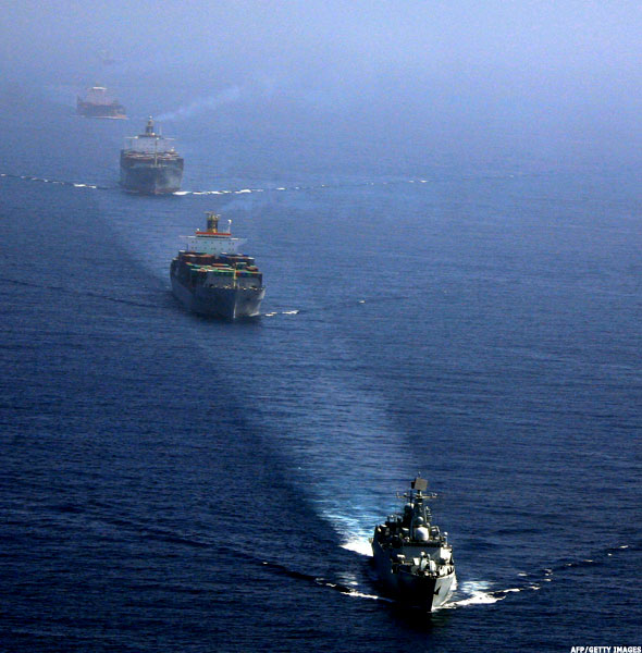 Warships escort merchant vessels in Gulf of Aden.