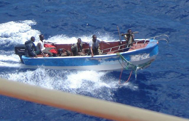 This is the second generation - a fibreglass whaler - shorter and stubbier, but able to carry enough armed men - five here in this case - one carrying the RPG for intimidation. The others likely armed with AK-47 assault rifles. And armed even with an aluminum ladder to make boarding easier. Note the amateurish blue paint job on the hull, meant to make the attack boat less noticeable as it sneaks up. One engine and 5 guys tells us that this is group that can afford a better boat but is not yet in the major leagues.